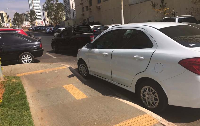 O condutor do carro branco parou em cima da rampa de acesso para cadeirantes e não deu nem sinal de vida